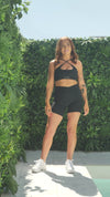 A video of Chelsea the model from photoshoot day, showing off her outfit. She is wearing the Black Lavish Bike Shorts and Black Majestic bra.