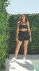 A video of Chelsea the model from photoshoot day, showing off her outfit. She is wearing the Black Lavish Bike Shorts and Black Majestic bra.