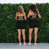 Chelsea and Bonnie facing the green wall showing off the back details of their Shorts.Chelsea is in the Bike Short length, Bonnie is in the Midlength shorts.